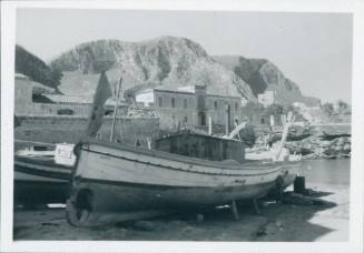 Grounded fishing boat in the foreground with the village and cliffs of Porticello in the background