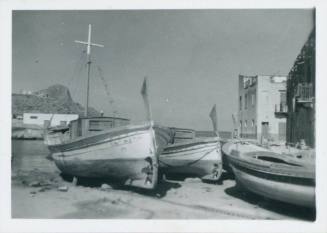 Three grounded fishing boats in foreground with Porticello and the sea in background