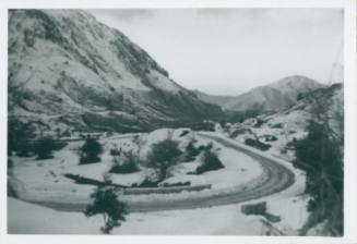 Scenic view of snow covered mountains, with a plowed circular road in the foreground