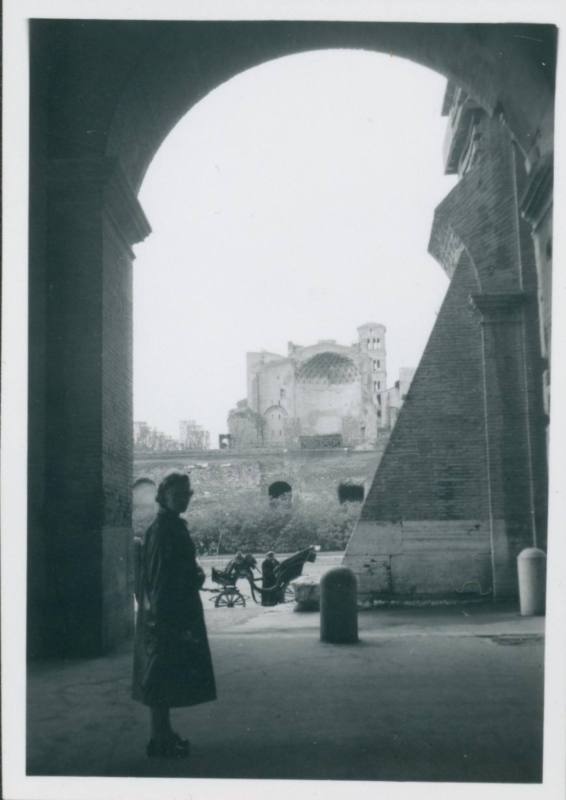 WBG standing under arches in Rome looking back at the camera