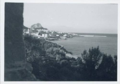 View of ocean and fishing village from the terrace of Villa Maggiacomo, Palermo, light sky.