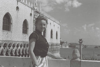 WBG with the back of the Doge's Palace, Venice, and water behind her